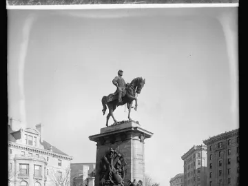 Major General George B. McClellan equestrian statue on an ornate pedestal in a park beside a road.