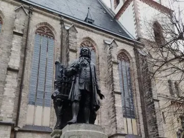 New Bach Monument: a bronze statue of Johann Sebastian Bach on a stone pedestal in front of a church.