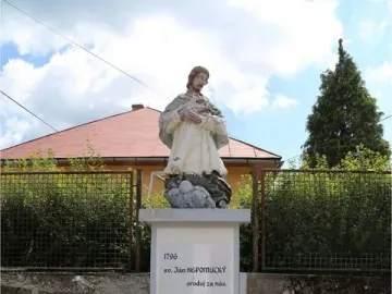 Stone statue of St. John of Nepomuk on a tall inscribed pedestal with three steps in front.