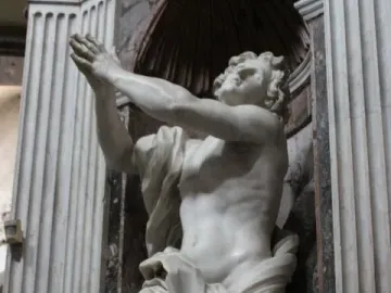 Bernini\'s Daniel and the Lion in white marble, shown kneeling with arms raised in a dark niche.