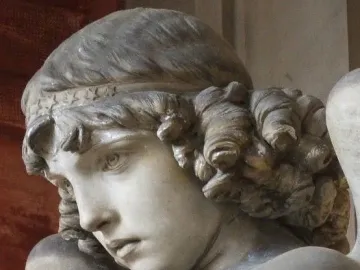 Close-up of Monteverde Angel showing the sculpture’s youthful face, wavy hair, and star-patterned headband.