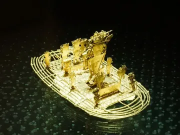 The Muisca Raft, a small gold raft sculpture with several figures standing on deck.