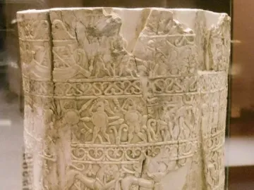 Situla of the Pania, a light-colored carved ivory vessel with horizontal bands of relief figures and decorative patterns, showing wear and damage at the rim.