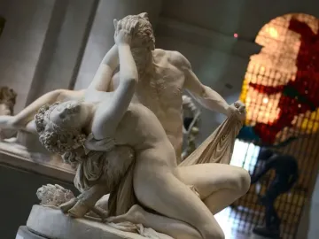 Satyre et bacchante sculpture of two figures embracing, with the male figure covering his face and the female figure reclining against him.