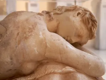 Close-up of the reclining Sleeping Maenad marble sculpture, showing the back, shoulder, and head of the sleeping figure.