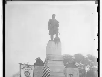 Admiral David G. Farragut statue with naval decorations at the base and an American flag nearby.