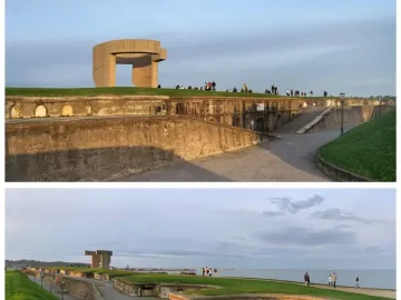Elogio del Horizonte concrete sculpture against a cloudy sky, with two people walking on the grass below and the ocean in the background.