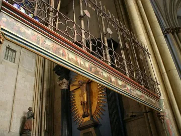 Gero Cross crucifix displayed high inside Cologne Cathedral beneath a painted frieze and ornate screen.