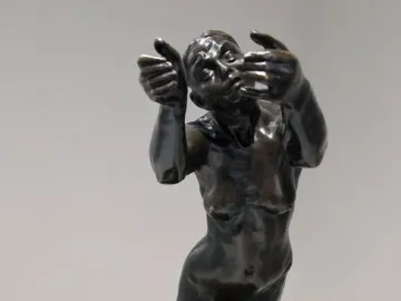 The Implorer bronze sculpture of a kneeling nude woman with raised hands and an upward gaze.