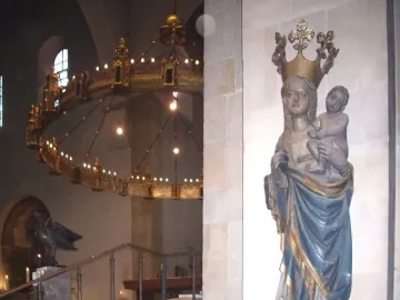 Inkpot Madonna statue of a crowned woman holding a child in blue and gold robes inside a cathedral