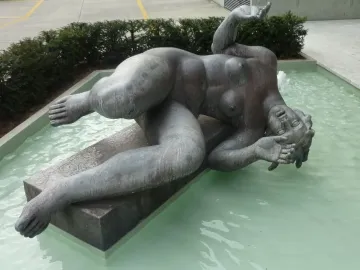 La Rivière by Aristide Maillol, a reclining nude female sculpture in a shallow pool with a small water jet nearby.