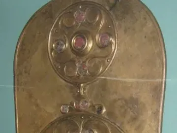 The Battersea Shield with three vertical circular bosses decorated with swirling patterns and red and pale inlays.