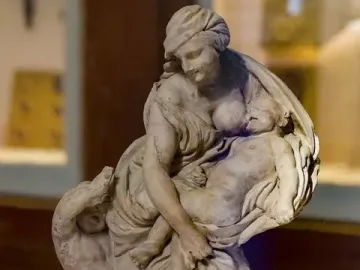 Bernini’s Charity with Two Cherubs, a draped female figure holding a small body with another child-like figure at her side.