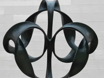 Continuum sculpture with dark metal looping ribbons forming circular openings.