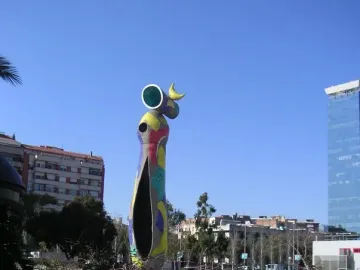 Dona i Ocell sculpture with a colorful mosaic surface against a clear blue sky.