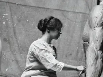 A female sculptor shapes a clay leg for the Fountain of Time.