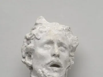 Head of Saint John the Baptist sculpture with closed eyes and an open mouth, shown in a weathered white surface.