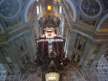 St. Peter\'s Baldachin beneath the ornate interior of St. Peter\'s Basilica, with a congregation gathered on the patterned floor.