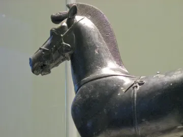 Bronze horse sculpture from a quadriga, shown in profile with a ridged mane and harness details.