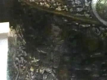 Close-up of the Baptistery of Saint Louis showing an ornate engraved section with a central human figure.