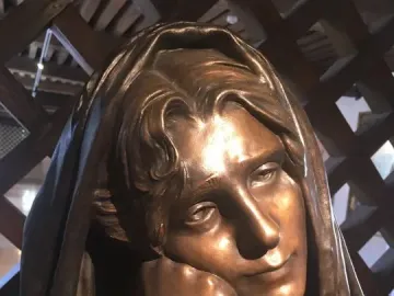 La Douleur bronze sculpture showing the head and shoulders of a figure with wavy hair and a hand resting under the chin.