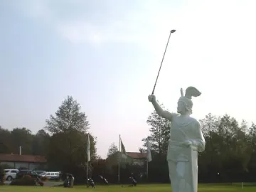 Hermannsdenkmal statue of a warrior holding a golf club on a manicured lawn.