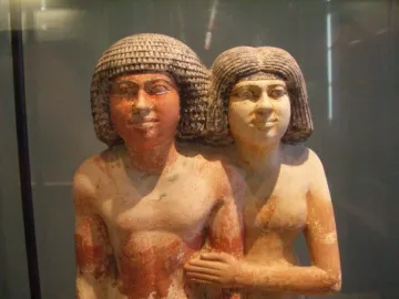 Raherka and Meresankh painted double statue of a man and a woman standing side by side, with the woman’s arm around the man’s waist.