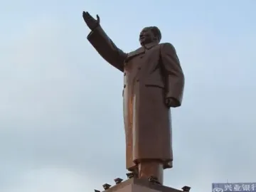 Long Live the Victory of Mao Zedong Thought monument with a raised-arm bronze figure on a pedestal and smaller figures around the base