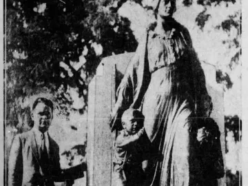 Man standing beside the Pioneer Mother Memorial sculpture showing a draped female figure with two smaller figures at her sides.