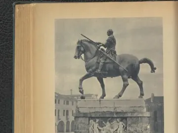 Gattamelata equestrian statue of an armored rider on a horse with one front leg raised, set on a decorated stone pedestal in a city square.