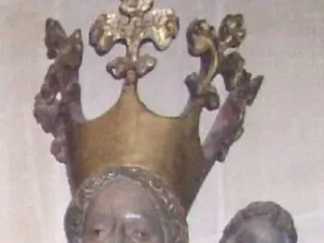 Inkpot Madonna showing a crowned woman in blue robes holding a child, who grips a small dark rounded object.