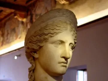 Juno Ludovisi marble bust with wavy hair and a composed expression on a decorated pedestal.