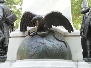 Tadeusz Kościuszko monument detail showing a bronze eagle with outstretched wings perched on a globe and gripping a snake.