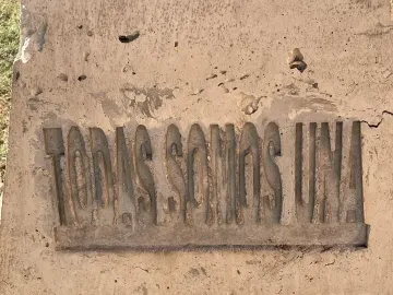 Close-up of the Antimonumenta showing the carved words “TODAS SOMOS UNA” on a weathered concrete panel.