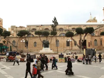 Great Siege Monument with three bronze figures on a white tiered base in front of a stone building