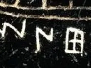 Etched alphabet inscription on a dark textured surface, likely from the Viterbo Rooster.