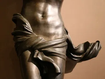 Bronze Corpus sculpture showing the midsection of a human torso with drapery wrapped around the hips and thighs.