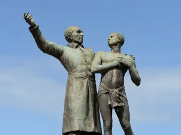 Victor Schœlcher statue showing one figure raising an arm beside a nearly nude man with a broken chain on his ankle.