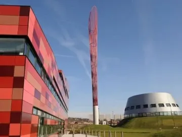 Aspire sculpture rising above the University of Nottingham Innovation Park, with modern buildings on either side.