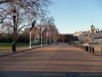 Horse Guards Memorial beside Horse Guards Road, with flagpoles, bollards, and a large historic building in the background.