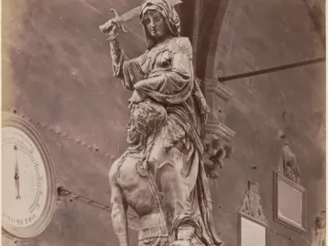 Donatello\'s Judith and Holofernes bronze sculpture, showing a robed woman holding a raised sword over a kneeling man she grips by the head.