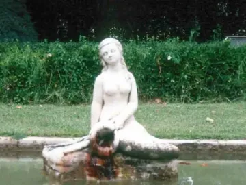 Mermaid Fountain statue of a mermaid sitting on a stone structure with water flowing into a basin