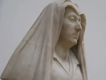 Bust of Camilla Barbadori in light-colored marble, showing a woman with a draped head covering and a dark pedestal.