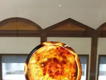 The Tazza Farnese, a translucent amber-and-orange carved cameo bowl on a silver stand in a museum setting.