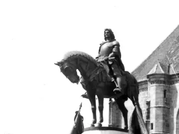 Matthias Corvinus Monument showing an armored rider on horseback atop a castellated stone pedestal, with figures and banners at the base.