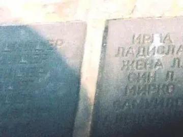 Two dark plaques on the Monument to the Victims of Fascism engraved with names in Cyrillic script.