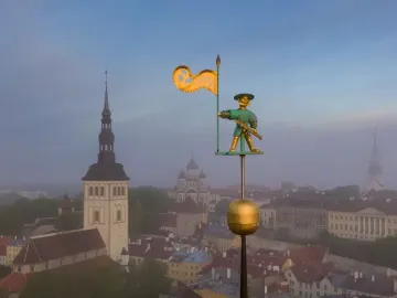 Old Thomas weather vane overlooking Tallinn’s old town skyline at dawn