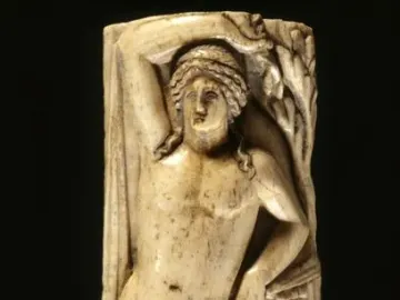 Apollino carved in relief, showing a nude male figure with one arm raised, a tree, drapery, and a lyre.