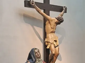 Pietà sculpture showing Mary holding the lifeless body of Christ, with a crucifix figure above them