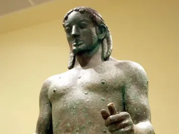 Detail of the Piraeus Apollo bronze statue with green patina and visible cracks.